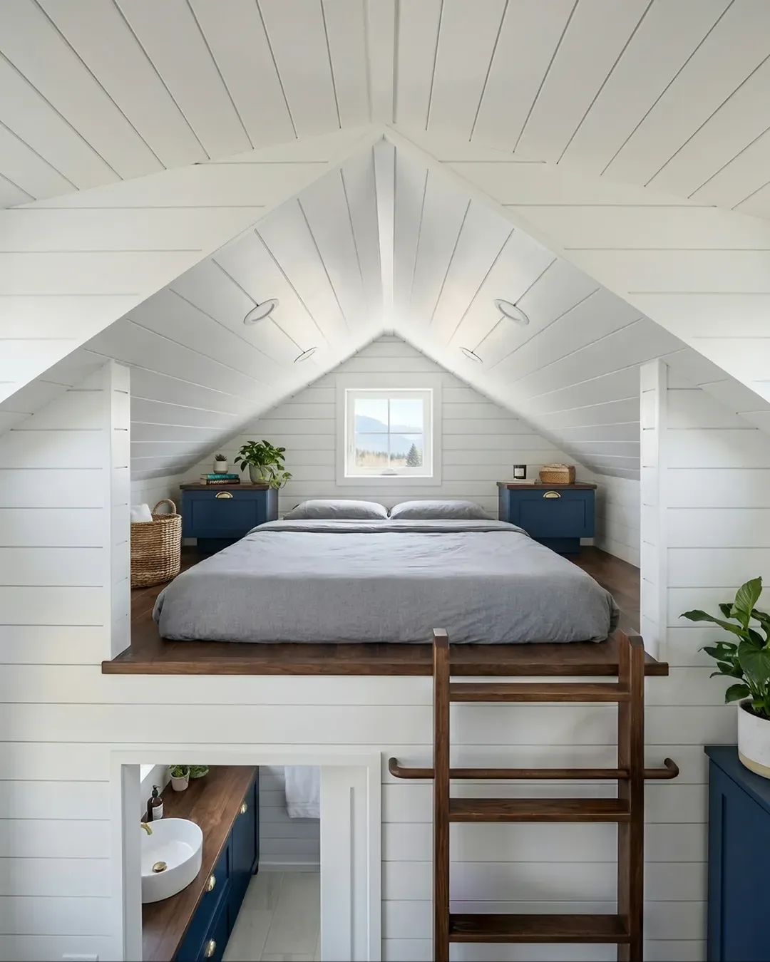 White loft bedroom with cathedral ceiling and blue nightstands — rural Texas tiny home interior