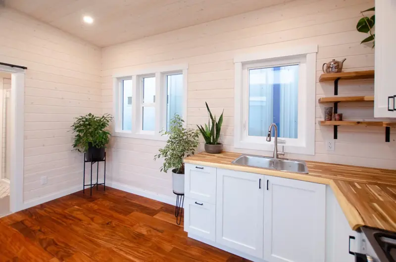 Modern Open Concept Tiny Home Kitchen with White Marble Countertops and Oak Accents